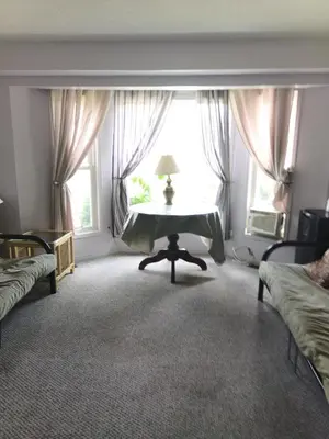 a bedroom with a table in front of a window at Princess Motel in Bobcaygeon