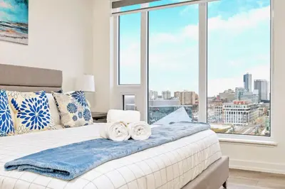 a bedroom with a bed with a large window at Condo Unit with Stunning Views & Amenities in Kitchener