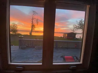 a view of a sunset from a window at Sunrise net cottage in Kawartha Lakes