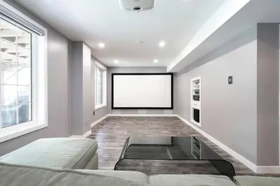 a living room with a couch and a blank screen at The Gate Chic & Cozy Basement Retreat in Ajax in Ajax