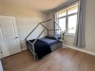 a bedroom with a canopy bed with a window at Luxury Home 2 mins drive to Saugeen Shores beach in Port Elgin