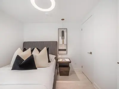 a bedroom with a bed with black and white pillows at Hazelton Suites - Yorkville - Indoor Pool & Hot Tub in Toronto