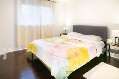 a bedroom with a large bed and a window at Stunning Vacation Home North of Toronto in Richmond Hill