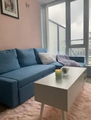 a living room with a blue couch and a coffee table at Bright 1BR w Large Terrace - Entertainment District in Toronto