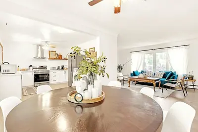 a kitchen and living room with a large wooden table at Walk to Lake - Old Town Retreat in Niagara on the Lake