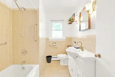 a bathroom with a sink and a toilet and a tub at Walk to Lake - Old Town Retreat in Niagara on the Lake