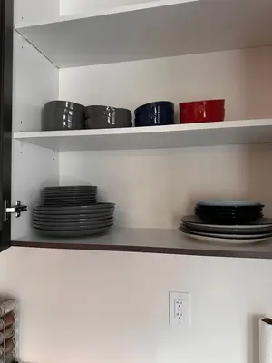 a shelf with plates and bowls in a kitchen at Cozy 5 bedrooms & 5 bathrooms House in Tottenham
