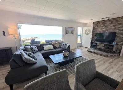 a living room with a couch and a flat screen tv at Cottage on Private Beach in Penetanguishene