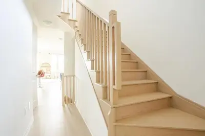 a staircase in a home with white walls and wooden floors at Stylish 4br Fast Wifi Sleeps 10 in Barrie