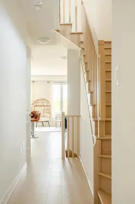 a staircase in a home with white walls and wood floors at Stylish 4br Fast Wifi Sleeps 10 in Barrie