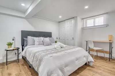 a white bedroom with a large bed and a desk at Modern 3 Bdr Homeapt Mins To Notlwineriesfalls in St. Catharines