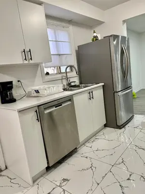 a kitchen with white cabinets and a stainless steel refrigerator at Private Room Near Airport K3 in Mississauga