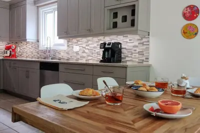 a kitchen with a wooden table with bowls of food on it at Birdsong Bungalow in Port Dover