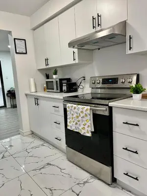 a kitchen with white cabinets and a stove top oven at Private Room Near Airport K5 in Mississauga