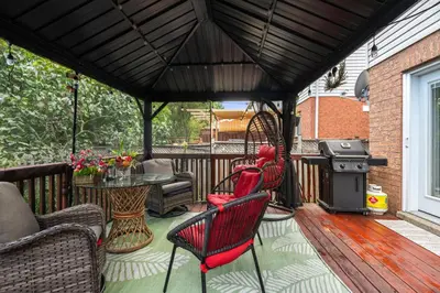 a gazebo with chairs and a grill on a patio at Ninos place in Hamilton