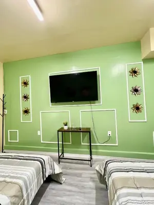 a room with two beds and a tv on a green wall at Private Room Near Airport K6 in Mississauga