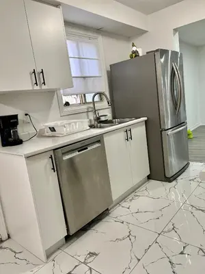 a kitchen with white cabinets and a stainless steel refrigerator at Private Room Near Airport K6 in Mississauga