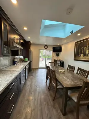 a kitchen with a wooden table and a blue light at Riverwood Home-Entire Rental Unit in Mississauga