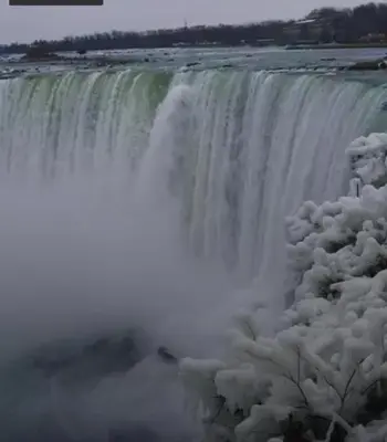 a waterfall is covered in snow at JNShortStay- Niagara Falls Area Hidden Gem in Welland