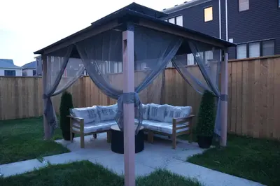 a gazebo with two benches in a backyard at JNShortStay- Niagara Falls Area Hidden Gem in Welland