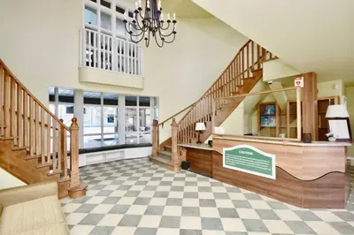 a large room with stairs and a chandelier at Stunning Condo with Access to Pool in Shanty Bay
