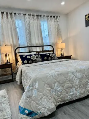 a bedroom with a bed with two lamps and two windows at K1 Private Bathroom Queen Bed Room in Mississauga