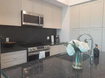 a kitchen with a vase of flowers on a counter at Nature trail view with cozy patio and firetable in Innisfil