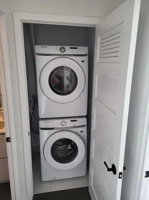 a washing machine and a washer in a small room at Nature trail view with cozy patio and firetable in Innisfil