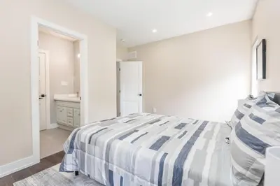 a white bedroom with a bed and a sink at Lake House By Lis in Innisfil