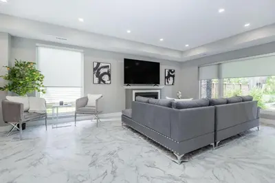 a living room with a large couch and a tv at Lake House By Lis in Innisfil