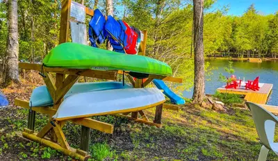 a picnic table with a green bench and a water slide at Summit Cottage on Kawagama Lake in Dorset
