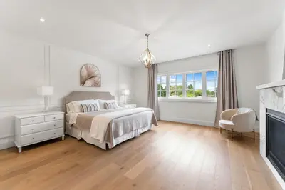 a white bedroom with a bed and a fireplace at Luxury Home - 5 min from airport, 15 to downtown in Toronto