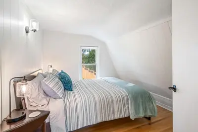 a white bedroom with a bed and a window at Queenston Cottage in Queenston