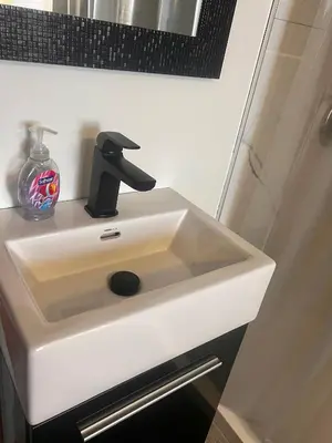 a white bathroom sink with a black faucet at Sunset Suites in Niagara Wine Country in Niagara on the Lake