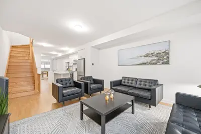 a living room with couches and a table at Private Room M A P L E with Attached Full Bathroom in Toronto, ON, Canada in Toronto