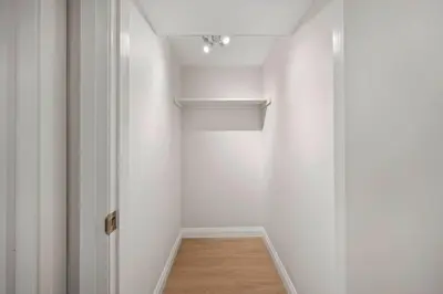 a hallway with a white wall and a ceiling at New 2 bedroom basement apartment in Guelph