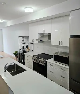 a kitchen with white cabinets and a sink and a stove at CEDAR Double Room with attached private Bathroom and Balcony in Toronto, ON, Canada in Toronto