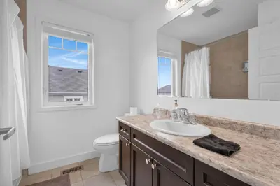 a bathroom with a sink and a toilet and a mirror at Entire 6BR 2 king 8 beds in total pets 3 GB WiFi in Kitchener