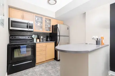 a kitchen with a stove and a refrigerator at Lakeside Haven - Cozy Townhome in Liberty Village in Toronto