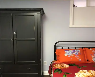 a bedroom with a bed and a black cabinet at SHAY-BASEMENT-Holiday Home in Pickering
