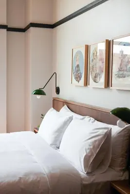 a bedroom with a bed with white sheets and pictures on the wall at The Postmark Hotel in Newmarket