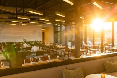 a restaurant with tables and chairs and a large window at The Postmark Hotel in Newmarket