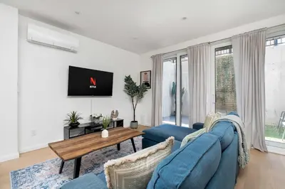 a living room with a blue couch and a table at Hidden Gem - 3 BR Steps to Little Italy and UofT in Toronto