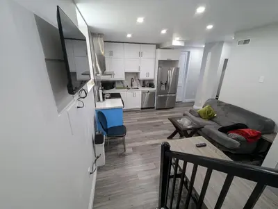 a living room with a couch and a kitchen at 2BR 1 king 1 Queen with parking 3 GBPS internet in Kitchener