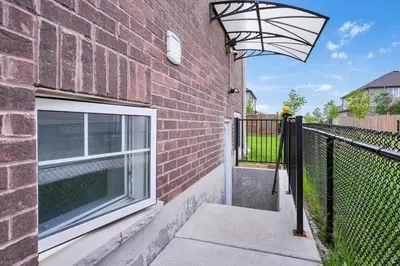 a brick building with a window and a fence at Modern 2BR Duplex 3.0 GBPS internet with Parking in Kitchener