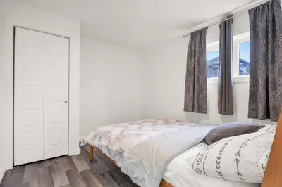 a white bedroom with a bed and a window at Modern 2BR Duplex 3.0 GBPS internet with Parking in Kitchener