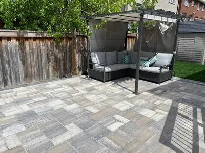 a patio with two couches under an umbrella at Modern, basement apartment, close to airport in Toronto