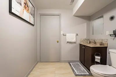 a bathroom with a toilet and a sink at Modern, basement apartment, close to airport in Toronto
