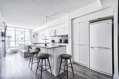 a kitchen with a counter and stools in it at Designer 2BR Downtown Condo, Rogers Center in Toronto