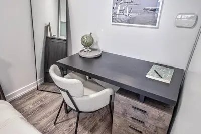 a black desk with two chairs and a vase on it at Designer 2BR Downtown Condo, Rogers Center in Toronto